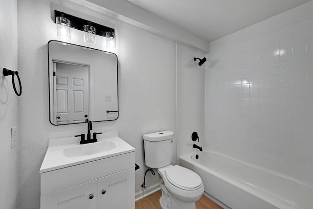 bathroom with vanity, shower / bathtub combination, wood finished floors, toilet, and baseboards