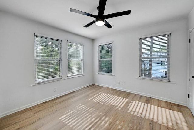 empty room featuring baseboards, a ceiling fan, and wood finished floors