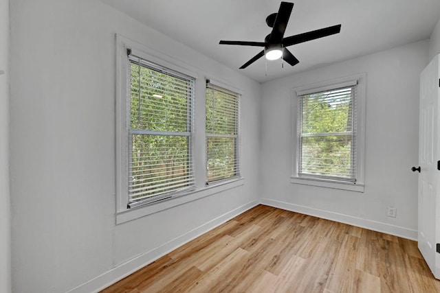 unfurnished room featuring a healthy amount of sunlight, baseboards, ceiling fan, and light wood finished floors