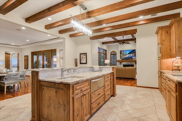 5525 City Park Rd Unit 6, Austin, TX 78730 - kitchen featuring open floor plan, a warming drawer, beamed ceiling, brown cabinetry, and a fireplace