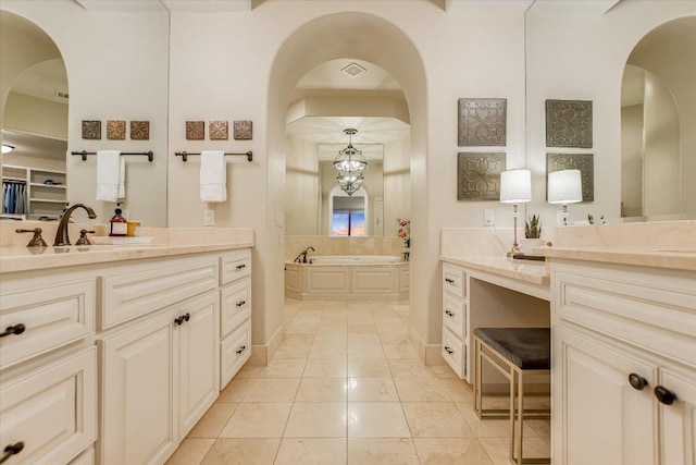 full bathroom featuring a chandelier, visible vents, a garden tub, and vanity