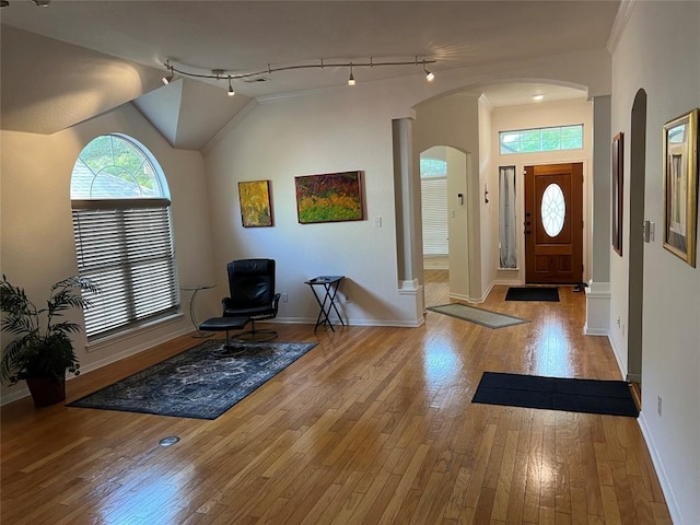 1728 Dapplegrey Ln, Austin, TX 78727 - entryway featuring arched walkways, wood-type flooring, lofted ceiling, and rail lighting