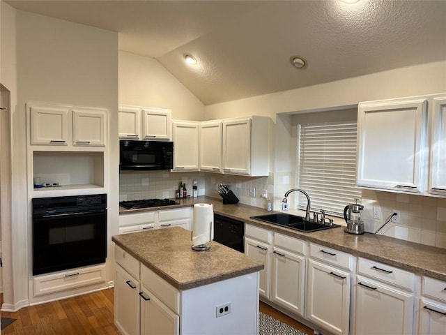 kitchen featuring white cabinets, backsplash, a sink, and black appliances