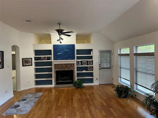 1728 Dapplegrey Ln, Austin, TX 78727 - unfurnished living room featuring a ceiling fan, healthy amount of natural light, built in features, wood finished floors, and crown molding