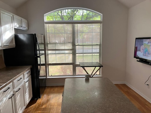 1728 Dapplegrey Ln, Austin, TX 78727 - kitchen featuring healthy amount of natural light, wood finished floors, white cabinets, and freestanding refrigerator