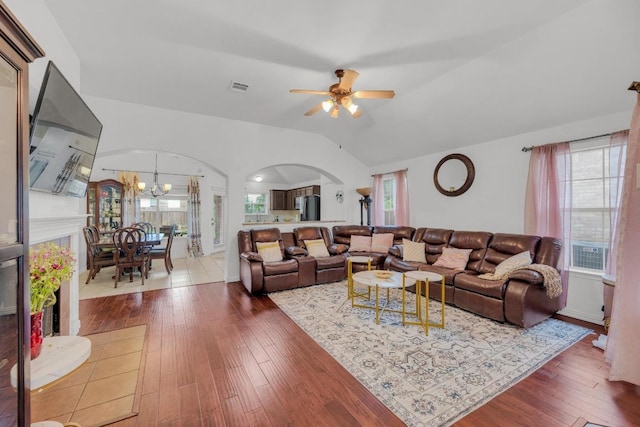 living room with arched walkways, visible vents, hardwood / wood-style flooring, and ceiling fan with notable chandelier