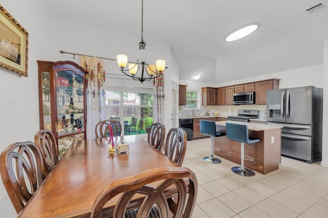 dining space with an inviting chandelier, light tile patterned floors, and visible vents