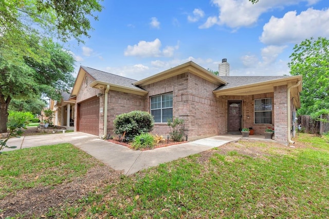 ranch-style house with a front yard, a chimney, brick siding, an attached garage, and driveway