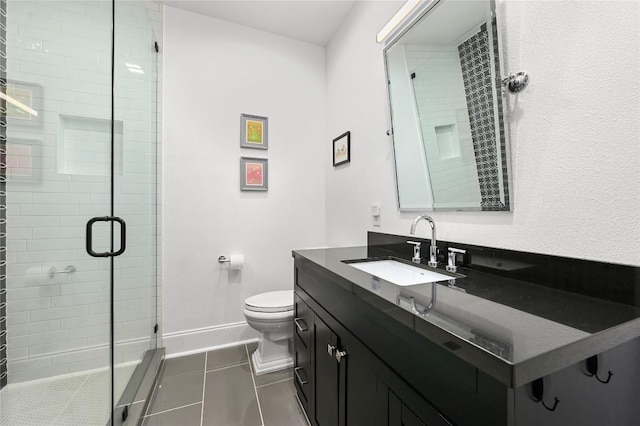full bath with tile patterned flooring, vanity, toilet, baseboards, and a stall shower