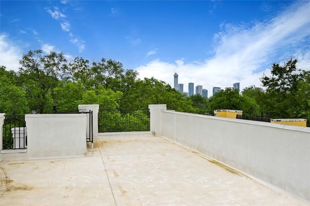 view of patio with a view of city, fence, and a gate