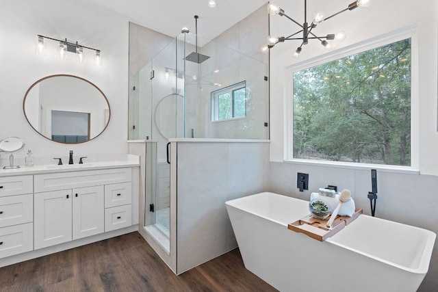 full bath featuring a freestanding tub, vanity, a stall shower, and wood finished floors