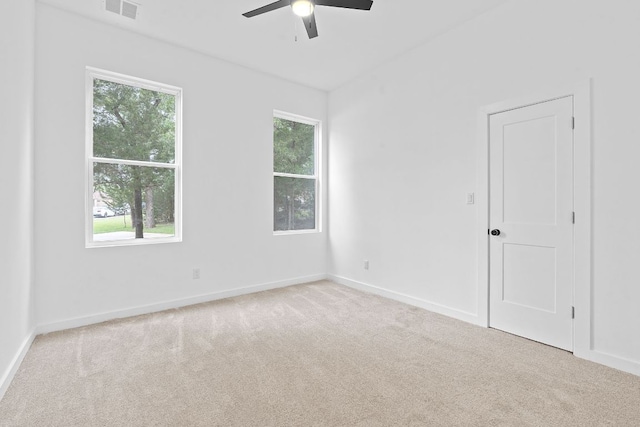 empty room featuring visible vents, carpet flooring, and a ceiling fan
