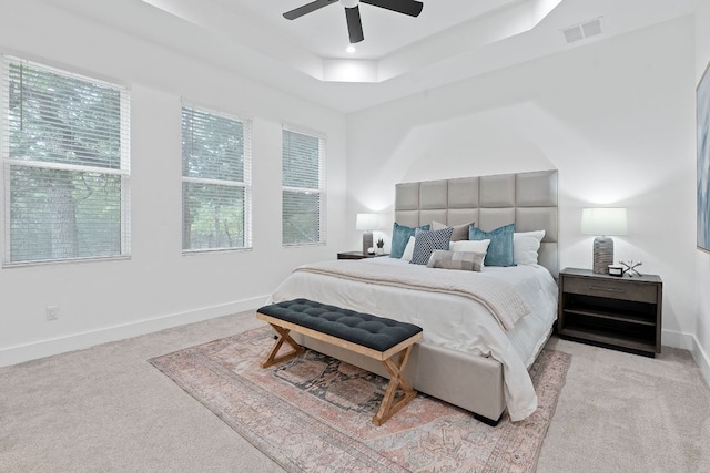 bedroom featuring visible vents, baseboards, ceiling fan, a raised ceiling, and carpet flooring