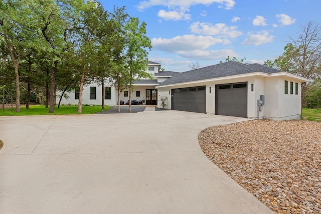 view of front facade with an attached garage, stucco siding, and driveway