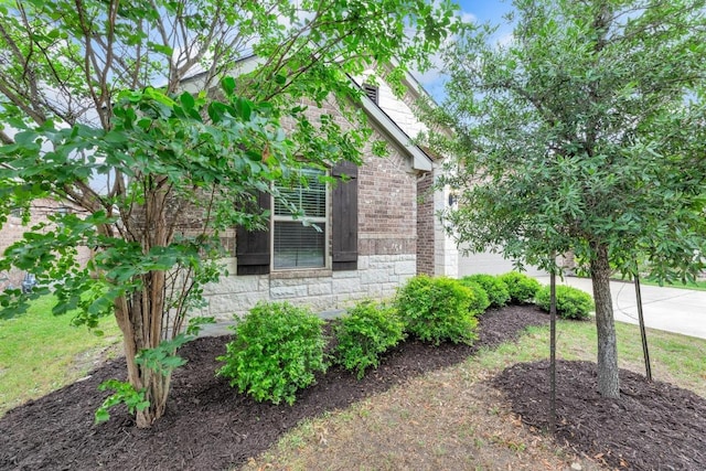 view of side of home with brick siding and stone siding