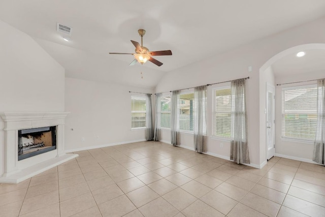 unfurnished living room featuring visible vents, a ceiling fan, lofted ceiling, arched walkways, and a premium fireplace