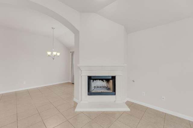 unfurnished living room with a fireplace with raised hearth, arched walkways, a chandelier, light tile patterned floors, and lofted ceiling