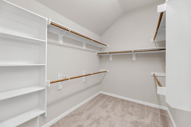 spacious closet with carpet flooring and vaulted ceiling