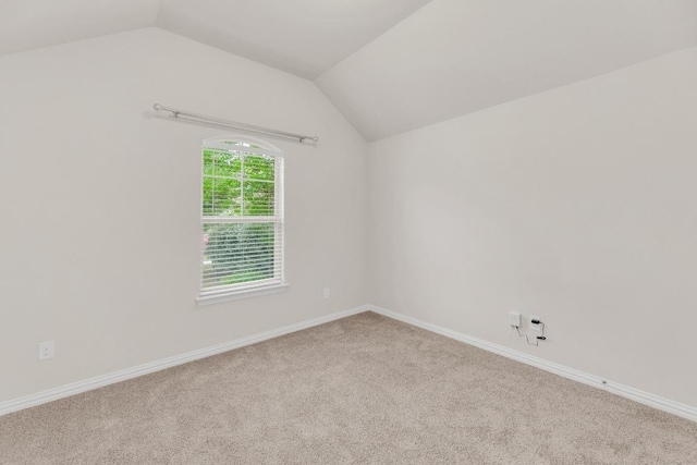 unfurnished room featuring baseboards, carpet, and lofted ceiling