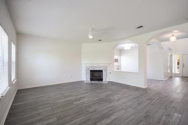 18816 Sandy Shore Dr, Pflugerville, TX 78660 - unfurnished living room featuring visible vents, baseboards, dark wood-style floors, a ceiling fan, and a premium fireplace