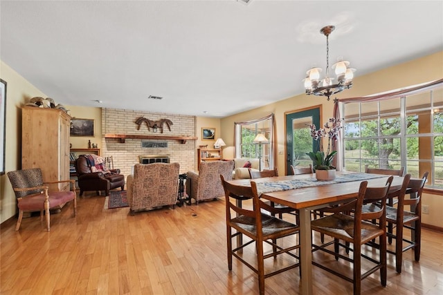 991 Fm 20, Cedar Creek, TX 78612 - dining room with light wood finished floors, a chandelier, and a fireplace