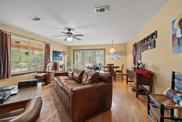 living area with visible vents, a ceiling fan, and light wood-type flooring