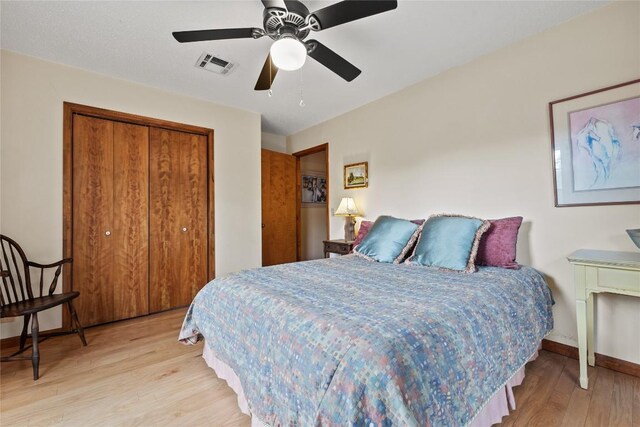 bedroom featuring light wood-style floors, a ceiling fan, a closet, and visible vents