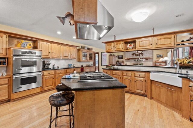 kitchen featuring exhaust hood, appliances with stainless steel finishes, open shelves, a sink, and light wood finished floors