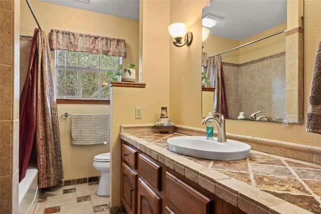 bathroom featuring vanity, shower / tub combo with curtain, and toilet