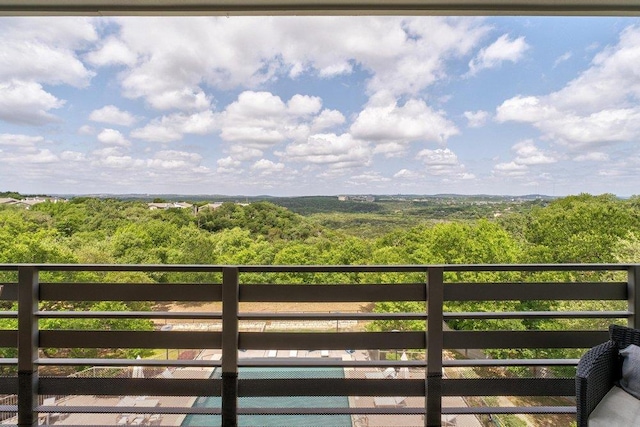 balcony featuring a wooded view
