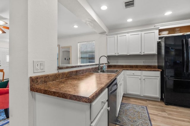 kitchen with visible vents, dark countertops, a sink, black appliances, and white cabinetry
