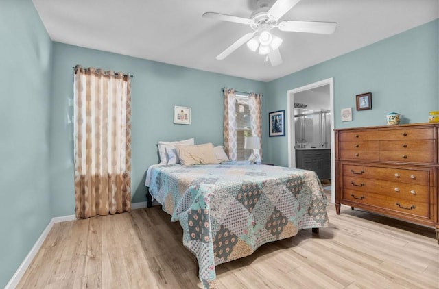 bedroom with baseboards, ceiling fan, wood finished floors, and ensuite bath