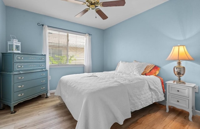 bedroom featuring baseboards, a ceiling fan, and light wood finished floors