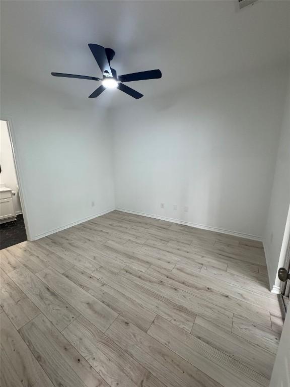 unfurnished room featuring baseboards, ceiling fan, and wood finished floors