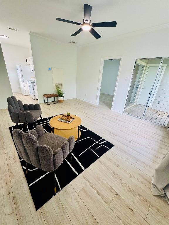 living room featuring a ceiling fan, visible vents, and wood finished floors