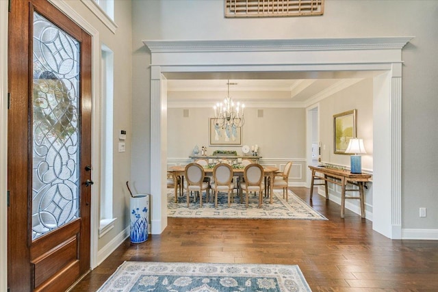 foyer entrance with an inviting chandelier, ornamental molding, visible vents, hardwood / wood-style floors, and a tray ceiling