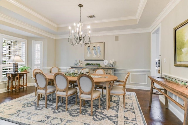 dining space with visible vents, a raised ceiling, a wainscoted wall, dark wood finished floors, and a notable chandelier