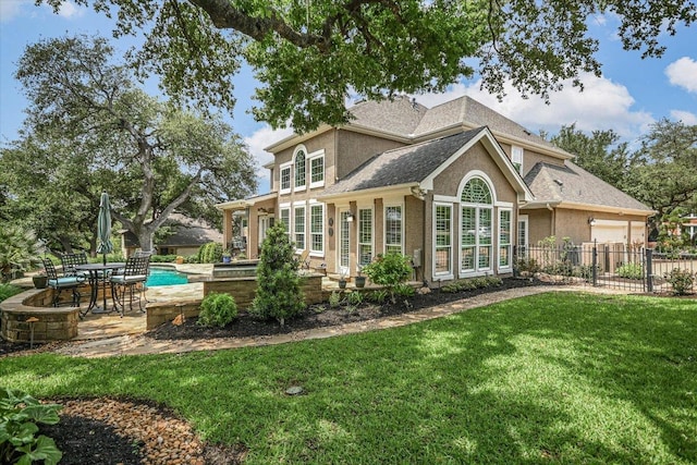 back of house with a garage, fence, a patio, roof with shingles, and a yard
