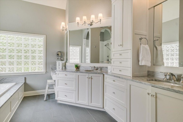 bathroom with baseboards, walk in shower, tile patterned flooring, and vanity