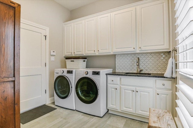 clothes washing area featuring a sink, cabinet space, and washer and clothes dryer