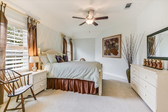 bedroom featuring a ceiling fan, baseboards, visible vents, and light carpet