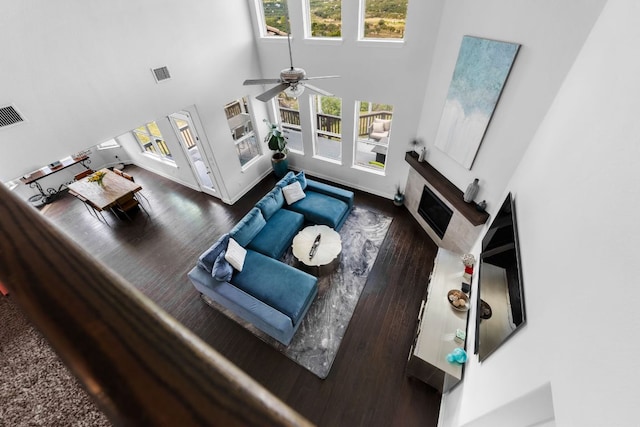 19600 Summit Glory Trl, Spicewood, TX 78669 - living room featuring visible vents, a glass covered fireplace, wood finished floors, a high ceiling, and a ceiling fan