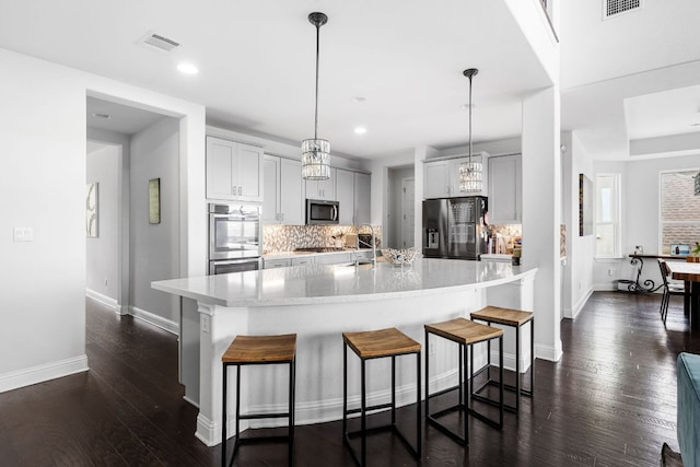 19600 Summit Glory Trl, Spicewood, TX 78669 - kitchen featuring backsplash, baseboards, appliances with stainless steel finishes, and visible vents