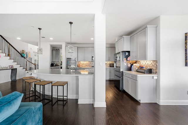 19600 Summit Glory Trl, Spicewood, TX 78669 - kitchen with backsplash, stainless steel appliances, a kitchen breakfast bar, and dark wood-type flooring
