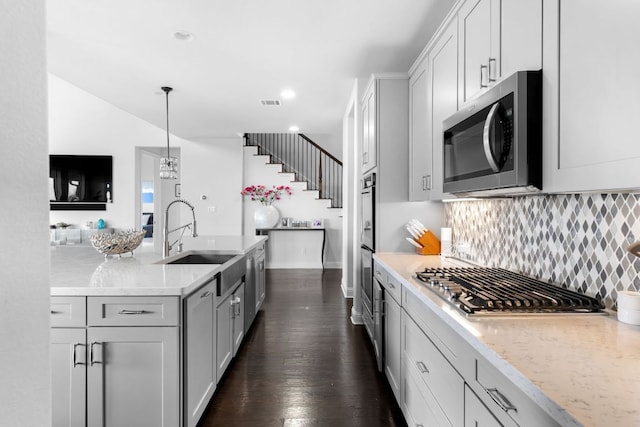 19600 Summit Glory Trl, Spicewood, TX 78669 - kitchen with tasteful backsplash, light stone countertops, a sink, dark wood-style floors, and stainless steel appliances