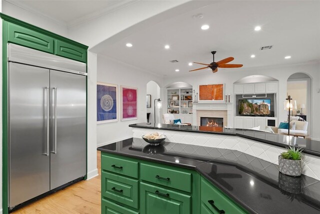 7921 W Rim Dr, Austin, TX 78731 - kitchen with stainless steel built in refrigerator, dark countertops, arched walkways, ceiling fan, and ornamental molding