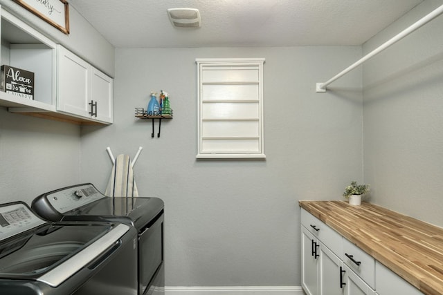 laundry room featuring baseboards, cabinet space, and independent washer and dryer
