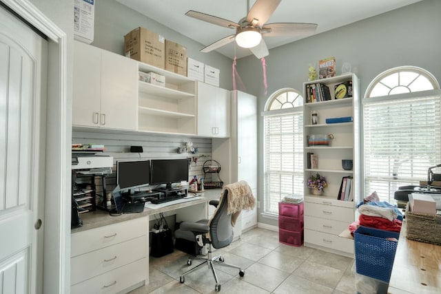 office space featuring built in study area, light tile patterned floors, and ceiling fan