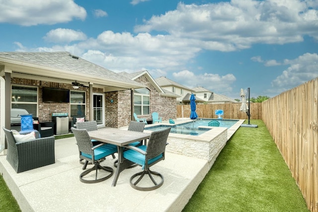 view of patio featuring a fenced backyard, outdoor dining space, and an in ground hot tub