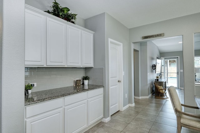 bar with baseboards, light tile patterned floors, and backsplash